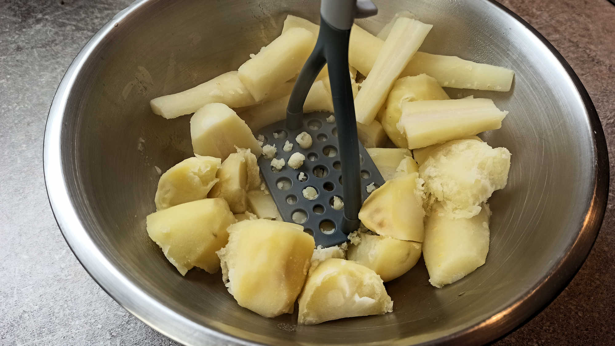 Écraser les pommes de terre et les panais avec un presse-purée