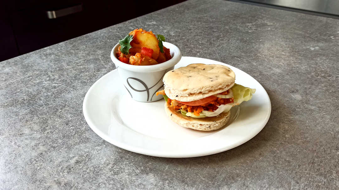 Burger au pain naan et poulet tikka masala et Bombay potatoes