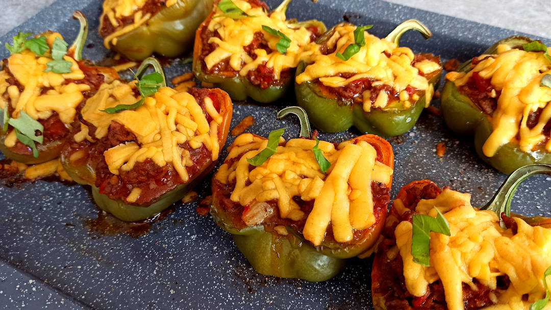 Hacher quelques de feuilles de basilic et décorer les poivrons farcis au bœuf tomates et cheddar