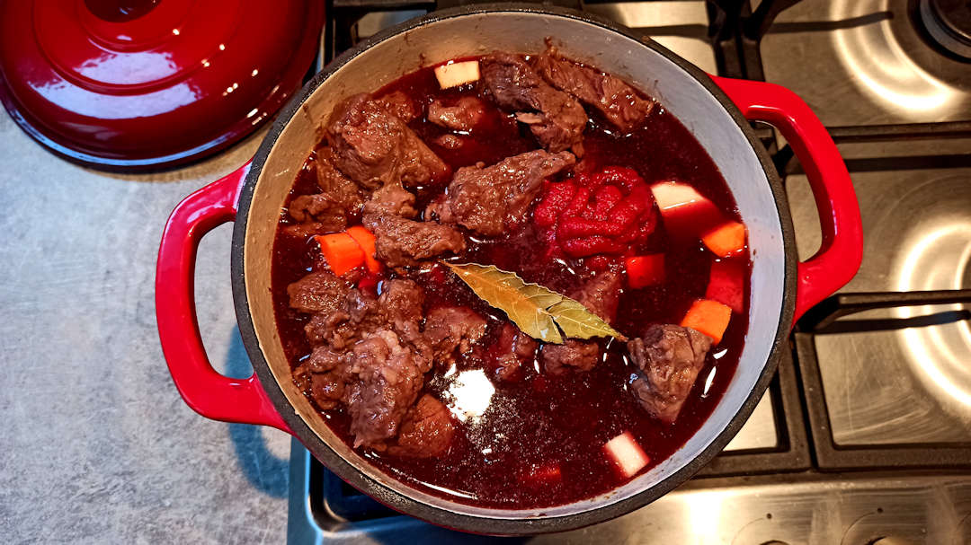 Ajouter les carottes, les panais, le concentré de tomate, la feuille de laurier, le reste du vin et le bouillon de légumes