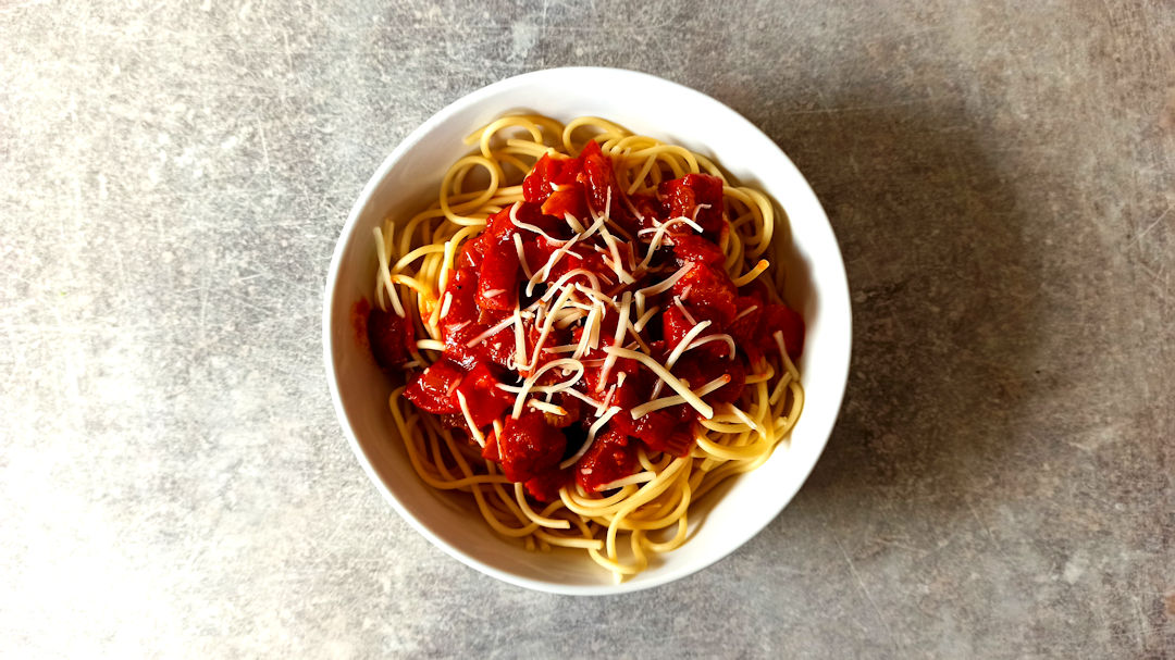 Présenter les spaghetti al salame avec du fromage râpé