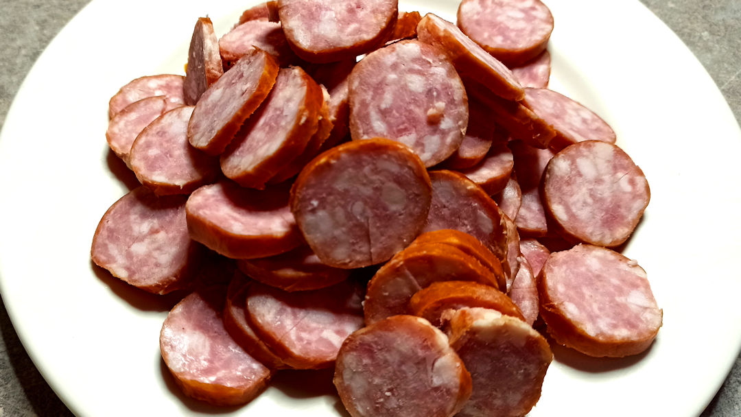 Couper les saucisses de Montbéliard en fines rondelles