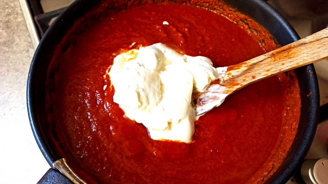 Incorporer la crème dans la sauce du poulet Tikka Masala maison